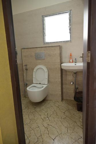 a bathroom with a toilet and a sink at Matree Grand Lodge in Guwahati