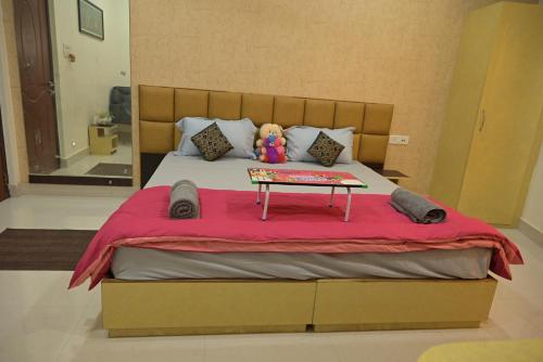 a bed with a teddy bear sitting on top of it at Matree Grand Lodge in Guwahati