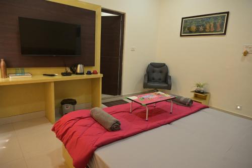 a room with a table on a bed with a desk at Matree Grand Lodge in Guwahati