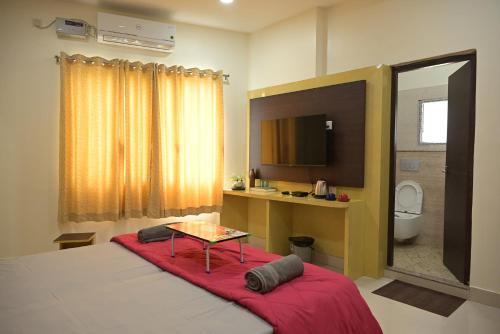 a bedroom with a bed with a table and a tv at Matree Grand Lodge in Guwahati