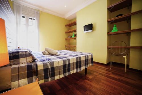 um quarto com uma cama com um cobertor xadrez em Canela Homes BARCELONA JARDINETS em Barcelona