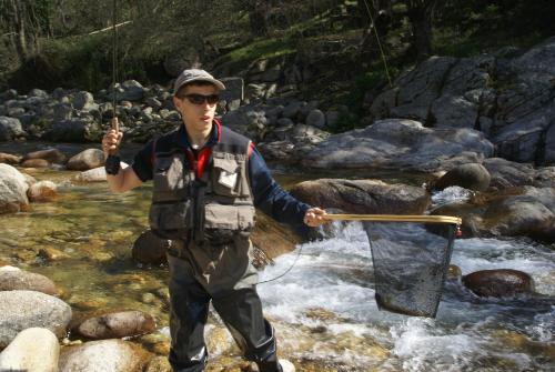 a man holding a net in a stream at Casa Rural La Canchalera in Losar de la Vera