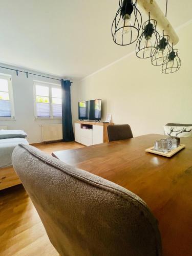 a dining room with a table and a room with a bed at Ferienwohnungen Anne in Schönebeck