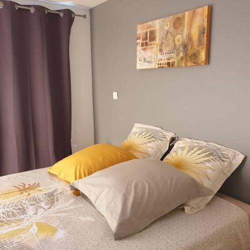 un lit avec deux oreillers dessus dans l'établissement Beau duplex au coeur du village, à Saint-Cyprien