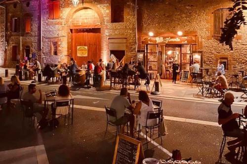 Un groupe de personnes assises à des tables dans une rue de la ville dans l'établissement Beau duplex au coeur du village, à Saint-Cyprien
