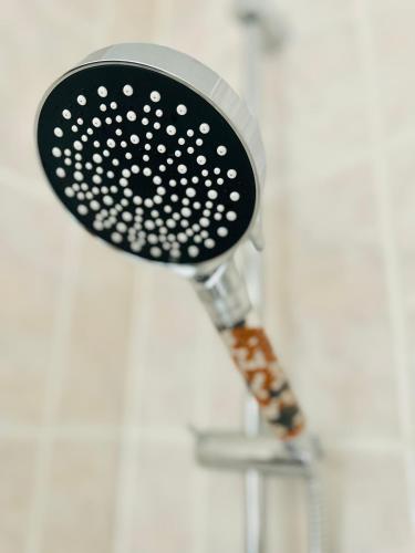 a shower head hanging on a white wall at Ferienwohnungen Anne in Schönebeck