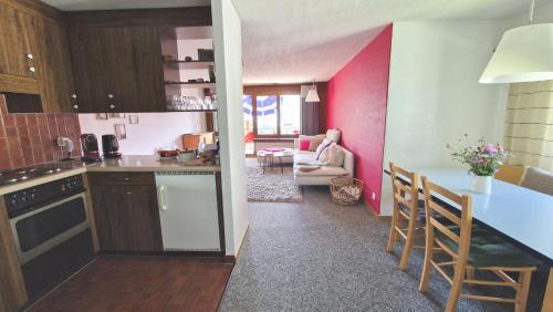 eine Küche mit rosa Wänden und eine Küche mit einem Tisch in der Unterkunft SunShine in Pany