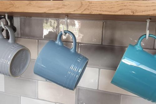 two blue bags hanging on a kitchen counter at Shoemakers Cottage, Halesworth in Halesworth