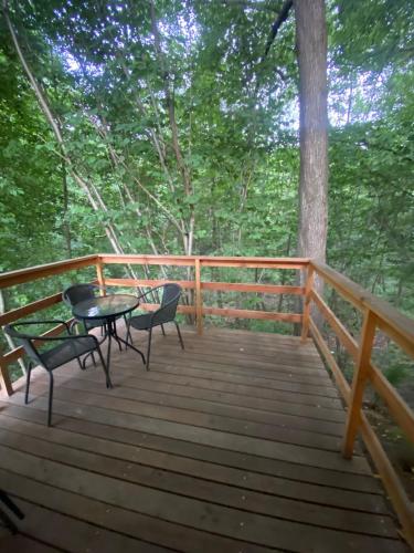 a wooden deck with a table and chairs on it at Apartamenty Domek na Roztoczu in Horyniec Zdrój