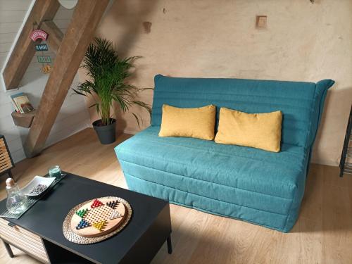 Sofá azul en la sala de estar con mesa en Cocoon Boisé, en Les Portes du Coglais