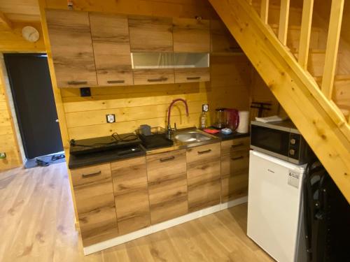 a kitchen with wooden cabinets and a sink at Apartamenty Domek na Roztoczu in Horyniec Zdrój