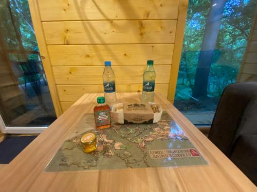 a table with two bottles on top of it at Apartamenty Domek na Roztoczu in Horyniec Zdrój