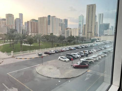 Une longue ligne de voitures garées sur un parking dans l'établissement Park view bedroom in family apartment, à Charjah