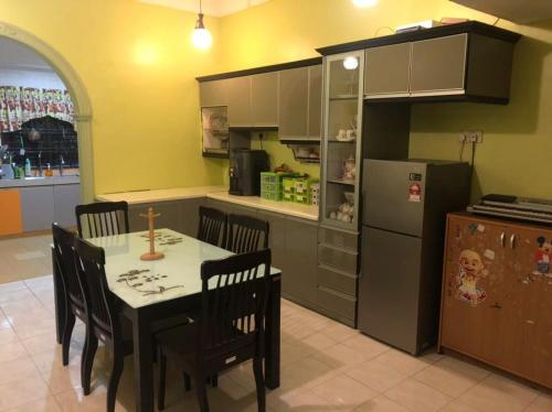 a kitchen with a table and chairs and a refrigerator at KJ Homestay Balok Kuantan in Kampong Chengal Lempong