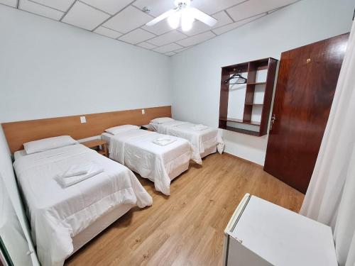 a hospital room with two beds and a mirror at Hotel Itapema in Valinhos