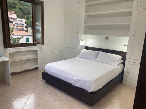 a bedroom with a bed with white sheets and a window at DA ARMÀ in La Spezia