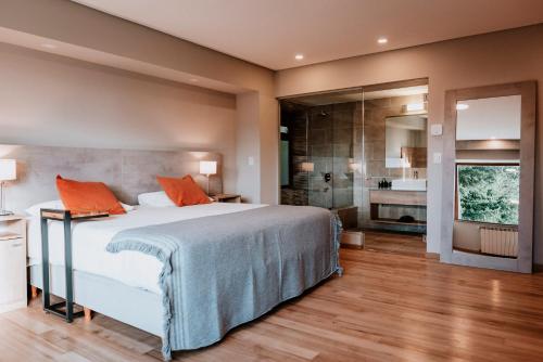 1 dormitorio con 1 cama grande con almohadas de color naranja en Basia Hotel & Sushi en San Carlos de Bariloche