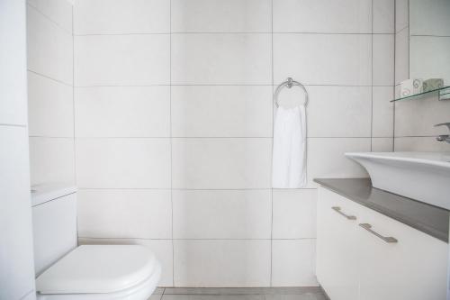 een witte badkamer met een toilet en een wastafel bij Villa Suri, Luxury Seafront Villa in Ayia Napa