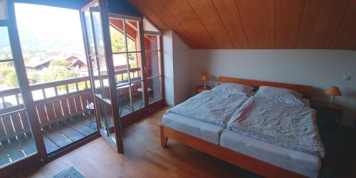 1 dormitorio con 1 cama y balcón en Ferienwohnung Bergblick im Tiefenweg 15A, en Lenggries