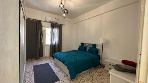 a bedroom with a bed with a blue comforter at Turkuaz Aparment in Amman
