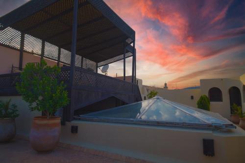 een hot tub aan de zijkant van een huis met een zonsondergang bij Riad Dar Pierre in Fès