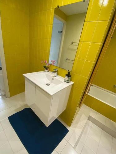 La salle de bains jaune est pourvue d'un lavabo et d'un miroir. dans l'établissement Coeur de Nice emplacement idéal, à Nice