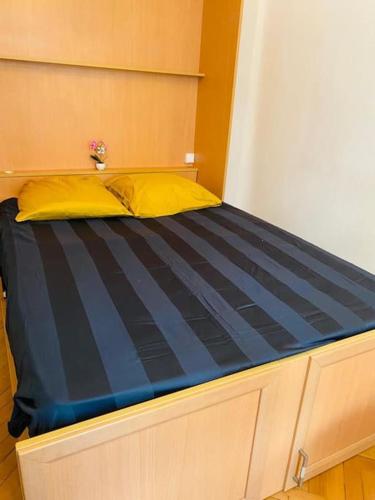 - un lit avec un oreiller jaune au-dessus dans l'établissement Coeur de Nice emplacement idéal, à Nice