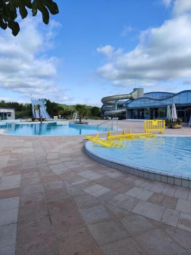 une grande piscine avec des chaises jaunes en face d'un bâtiment dans l'établissement L'Oustalet d'Erine - spacieuse et climatisée, à Albi
