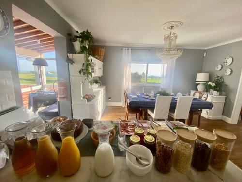 een keuken met een tafel met veel potten voedsel bij Quinta dos Bravos in Pico da Pedra