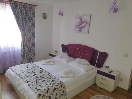 a bedroom with a bed with white sheets and pillows at Apartament Centru Vatra in Vatra Dornei