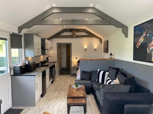 a living room with a couch and a kitchen at Wellsfield Farm Holiday Lodges in Stirling