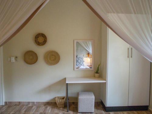 um quarto branco com uma mesa e uma janela em 701 Victoria Falls em Victoria Falls