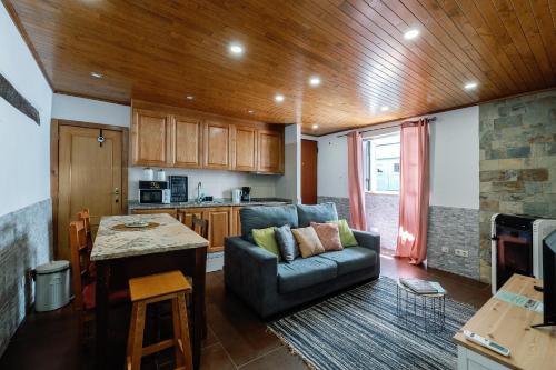 a living room with a couch and a kitchen at Casa do Javali in Bragança