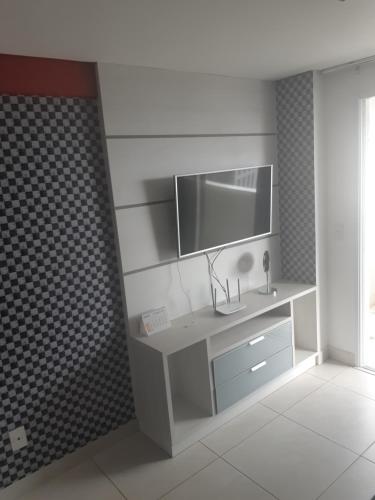 a bathroom with a sink and a tv on a wall at Brookfield Tower in Goiânia