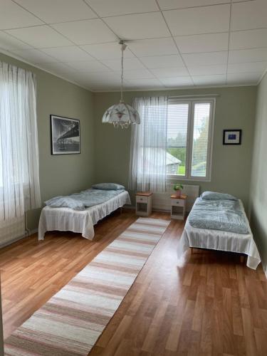 Un dormitorio con dos camas y una gran ventana. en Poppeli Guest House, en Kannus