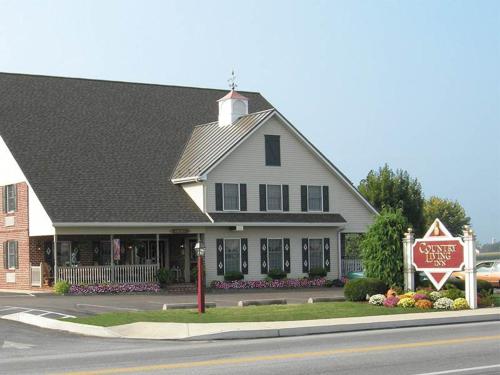 a large white house with a sign in front of it at Country Living Inn in Lancaster