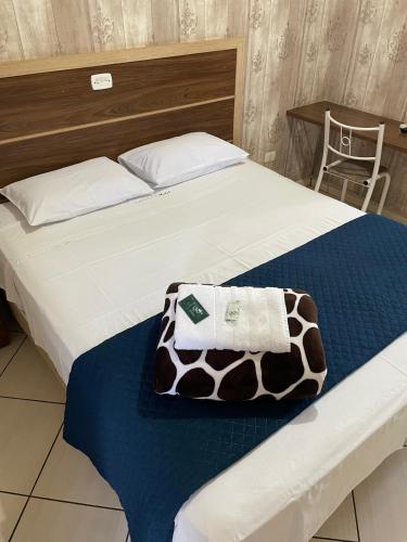 ein Bett mit einer braunen und weißen Decke drauf in der Unterkunft GUTIERREZ HOTEL in Americana