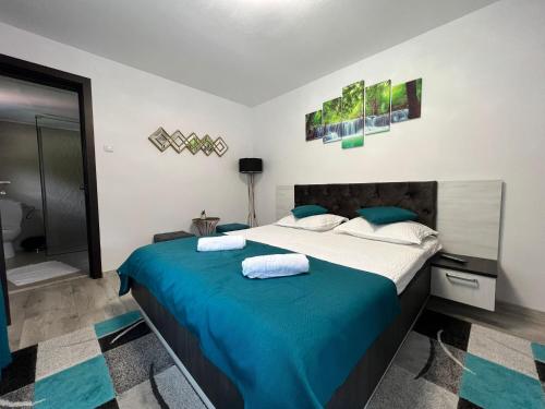 a bedroom with a large bed with blue sheets at Casa Cernat in Albac