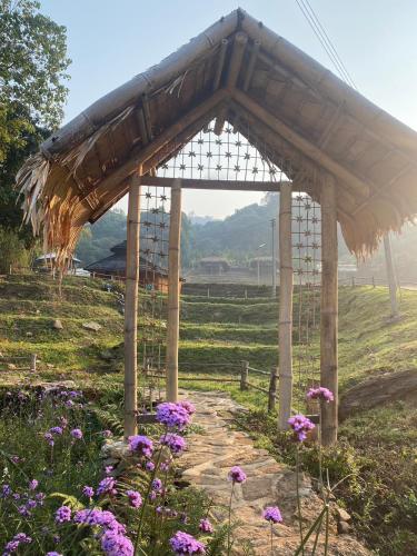 a wooden pavilion in a field with purple flowers at Daelorpu 2 แดลอปู in Ban Yang