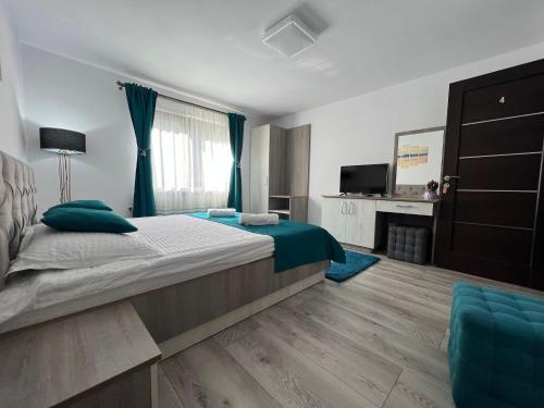 a bedroom with a large bed and a television at Casa Cernat in Albac