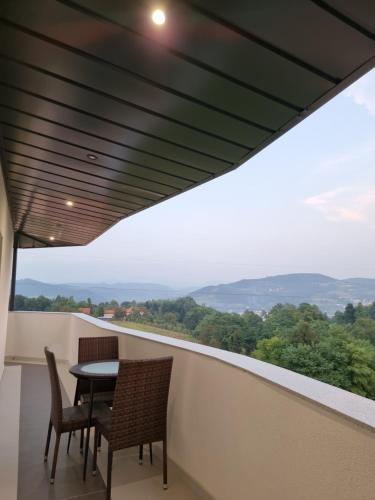 a balcony with a table and chairs and a view at Villa Park Ravne in Visoko