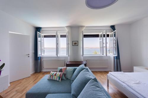 sala de estar con sofá azul y ventanas en Holiday Home Marija, en Dramalj