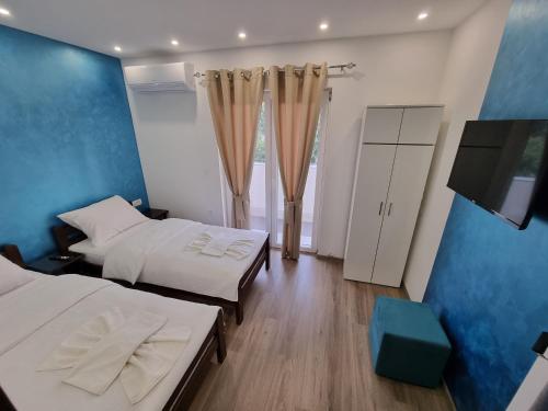 a room with two beds and a flat screen tv at Villa Park Ravne in Visoko