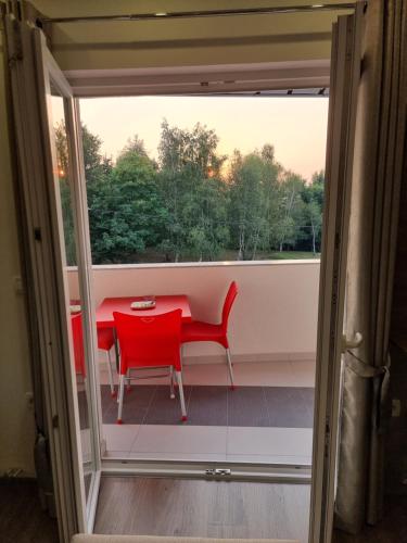 a red table and a red chair on a balcony at Villa Park Ravne in Visoko