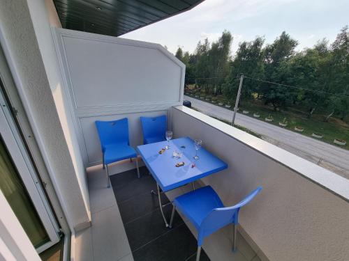 a balcony with a blue table and blue chairs at Villa Park Ravne in Visoko