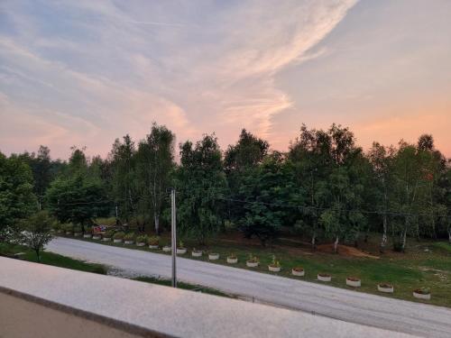 an empty road with trees and a cloudy sky at Villa Park Ravne in Visoko