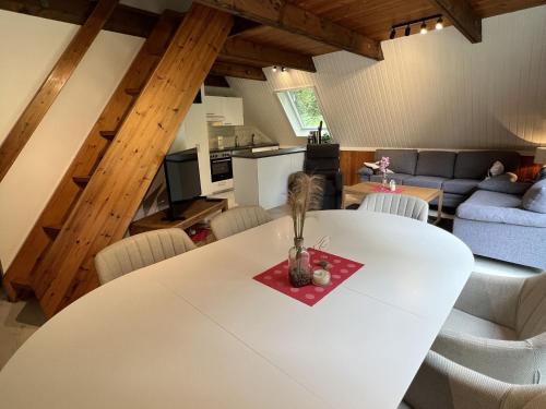 - un salon avec une table et des chaises blanches dans l'établissement Twistesee Ferienhaus 42, à Bad Arolsen