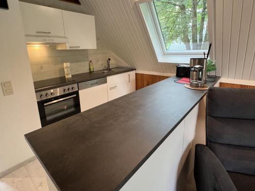 eine Küche mit einer schwarzen Arbeitsplatte und einem Herd in der Unterkunft Twistesee Ferienhaus 42 in Bad Arolsen