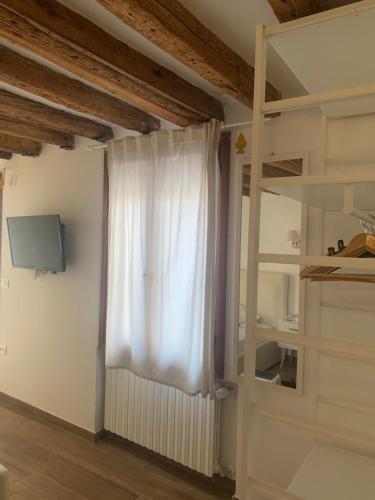 a room with a white curtain and a window at Casa Giardini in Venice