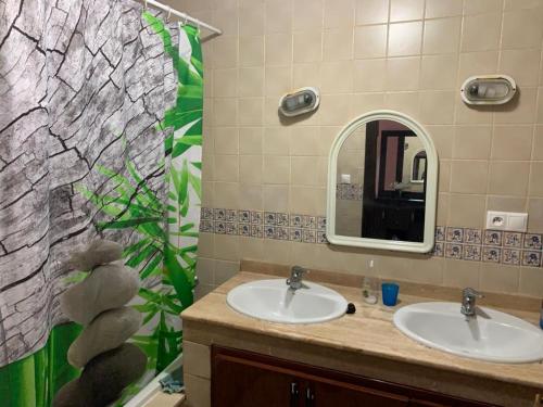 uma casa de banho com 2 lavatórios e um espelho em Ap6 em Saïdia
